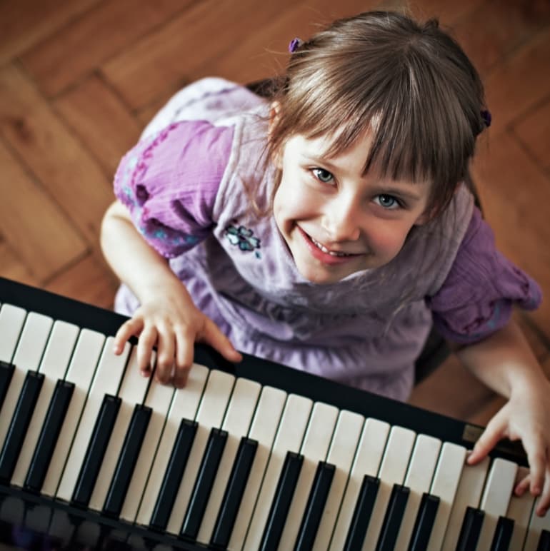 Child playing piano at CogniMusica
