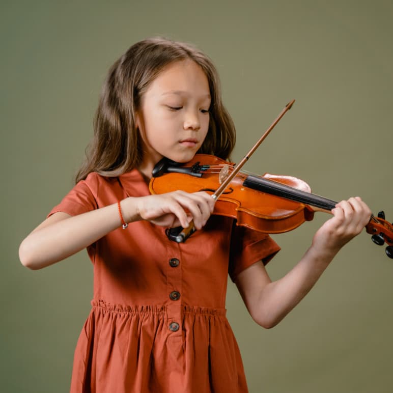Child playing violin at CogniMusica